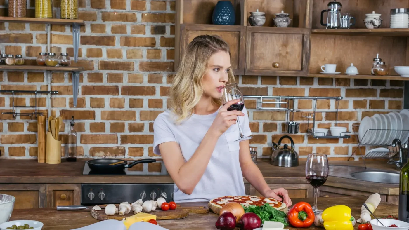 Tired mom holding glass of wine after a long day of parenting and work